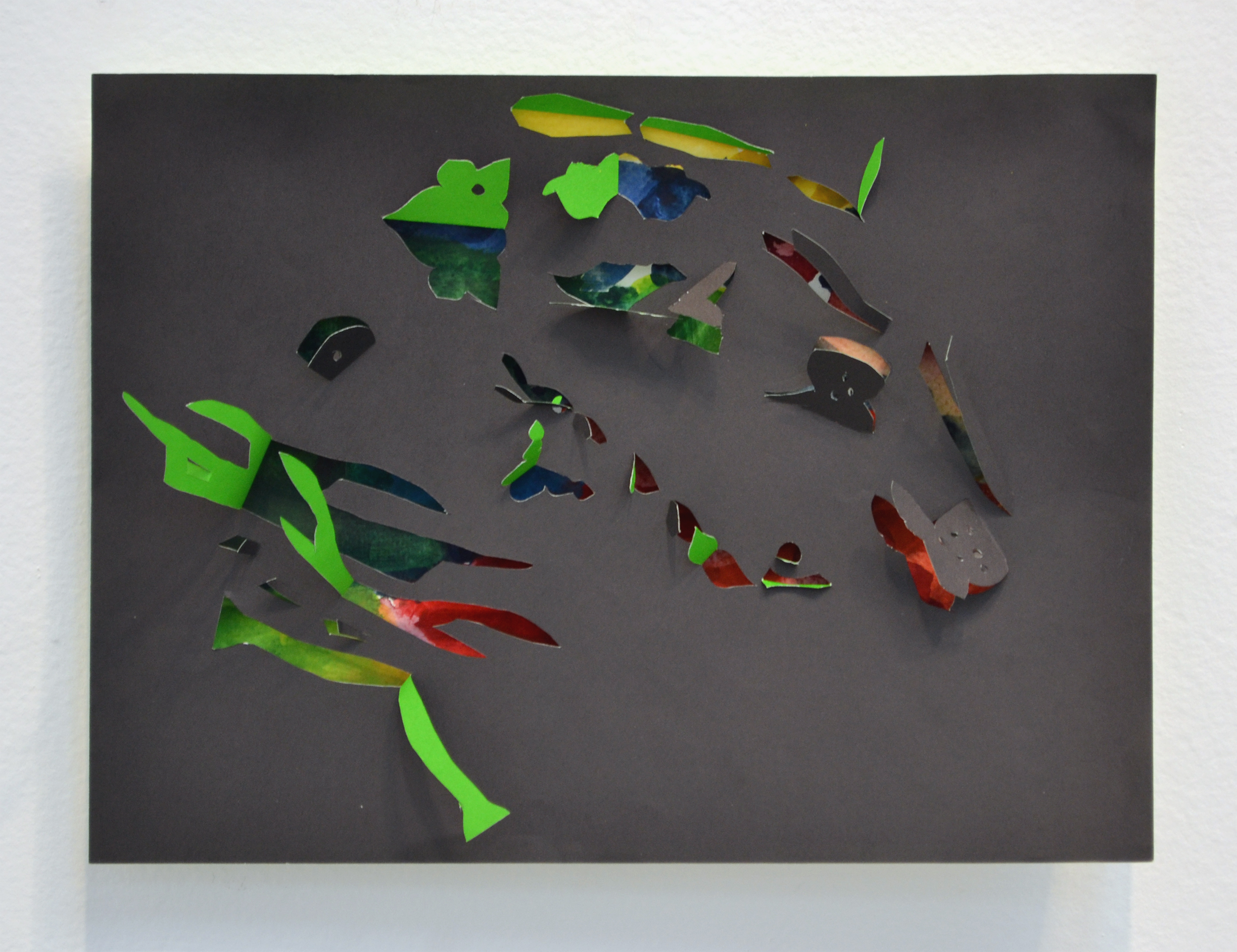 Black paper with shapes cut out, multi-colored paper showing through