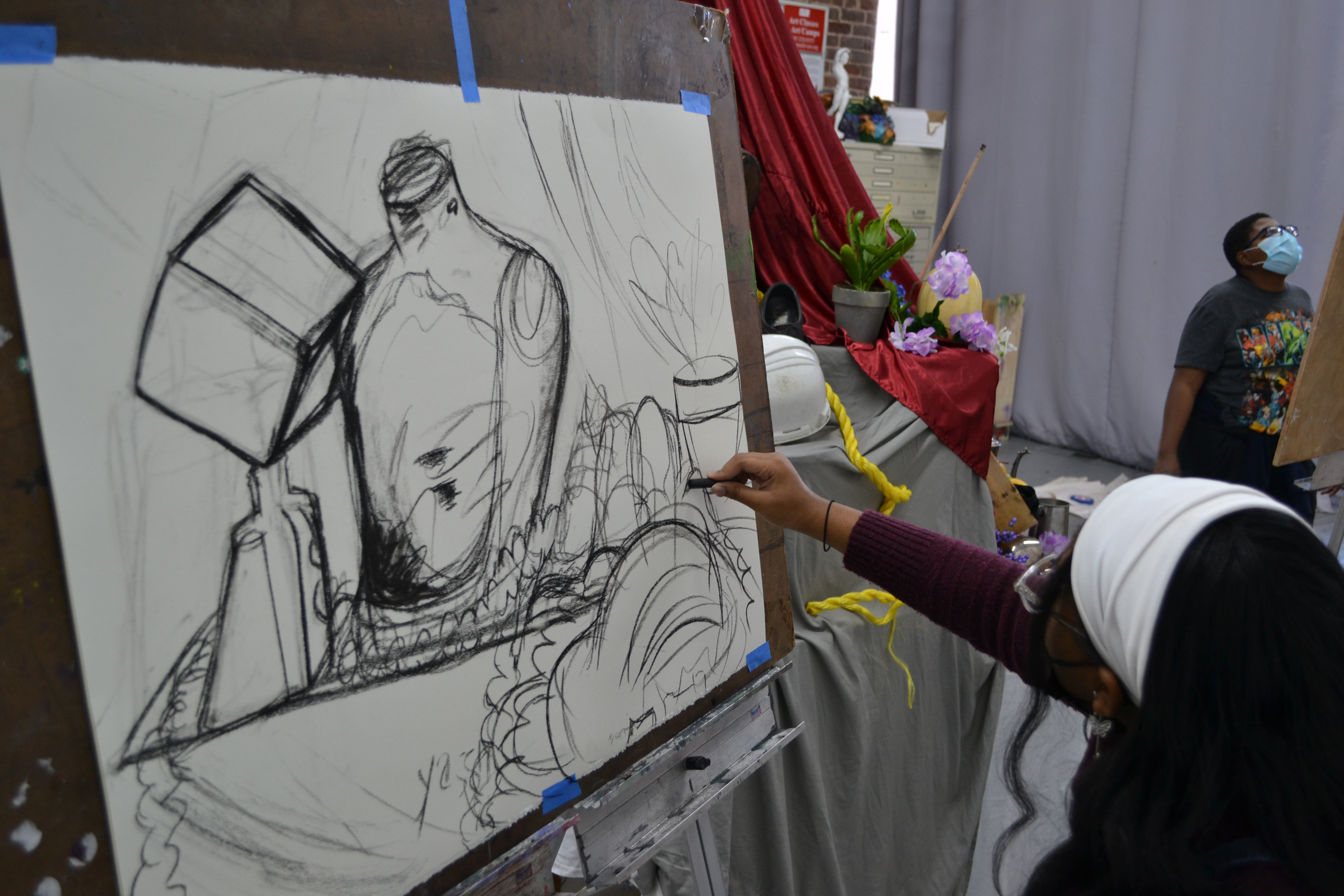 Young Artist working on a charcoal drawing from a still life